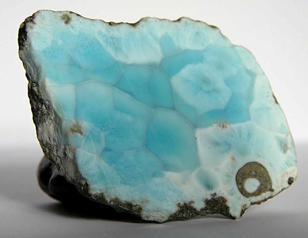 Larimar pulido visto de cerca: celdas azules irregulares separadas por vetas blancas